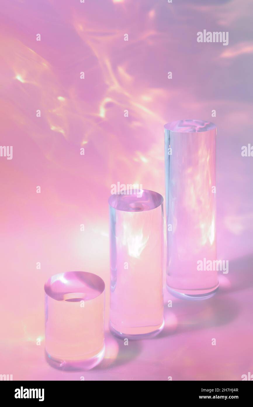 tre podi in vetro chiaro su sfondo rosa pastello Foto Stock