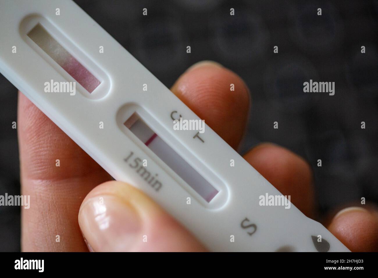 ILLUSTRAZIONE - 22 novembre 2021, Berlino: Una persona tiene una cassetta di prova dell'antigene SARS-COV-2 su un computer portatile. Il risultato del test è negativo. Foto: Fernando Gutierrez-Juarez/dpa-Zentralbild/ZB Foto Stock