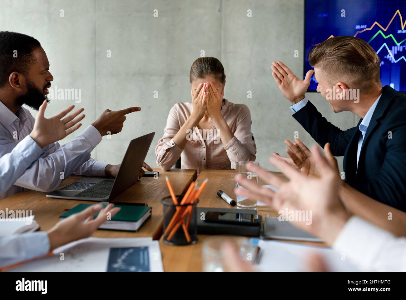 Stress sul luogo di lavoro. Gruppo di collagues urlando a Female Employee in Office Foto Stock