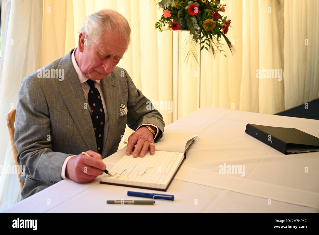 Il Prince of Wales firma un libro per i visitatori durante una visita all'Homerton College dell'Università di Cambridge, per discutere l'accesso all'istruzione e conoscere la visione del college di accogliere e sostenere studenti provenienti da diversi background. Data foto: Martedì 23 novembre 2021. Foto Stock