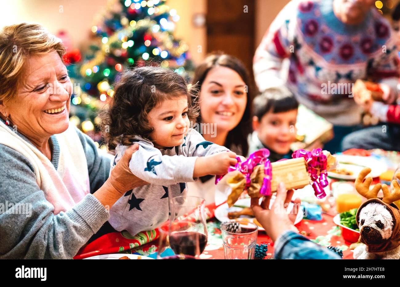 Grande famiglia multi generazione divertirsi a natale cena a casa - Vacanza invernale x mas concetto con genitori e bambini aprire i regali insieme Foto Stock