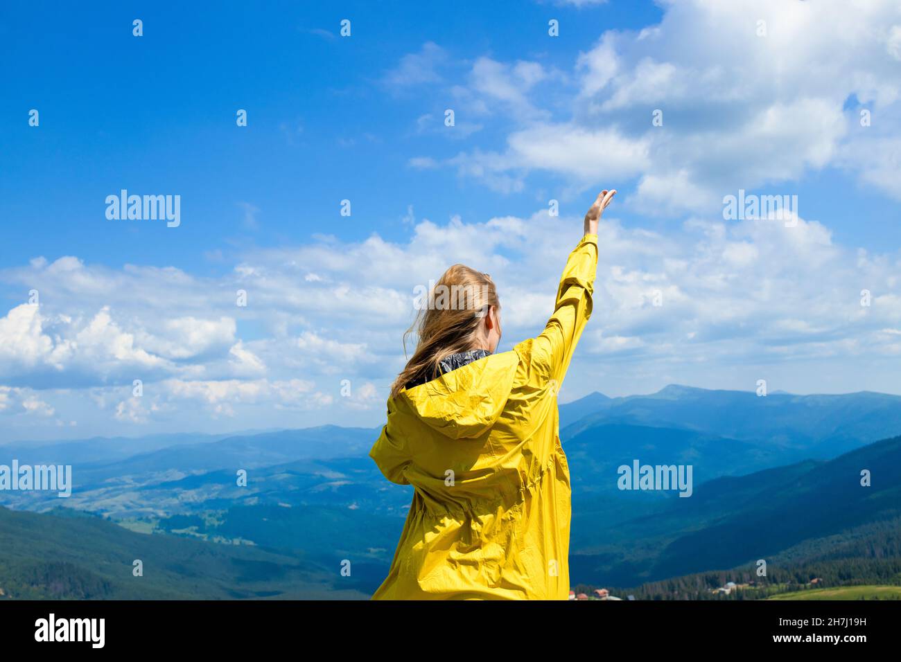 Donna di successo con le braccia sulla cima di una montagna in una giornata estiva soleggiata. Sport e concetto di successo Foto Stock