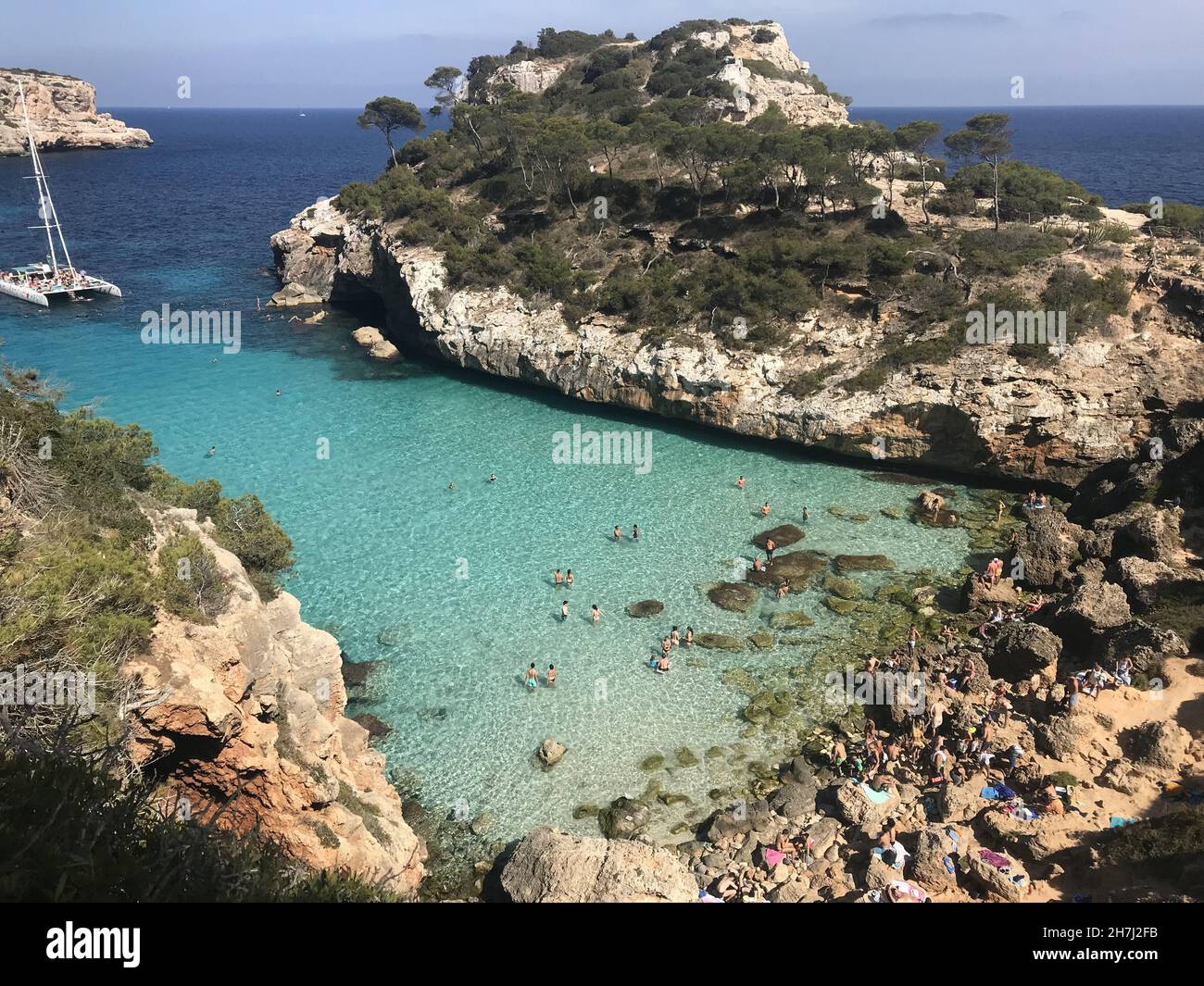 Bella spiaggia tra le scogliere con acqua di mare turchese Foto Stock
