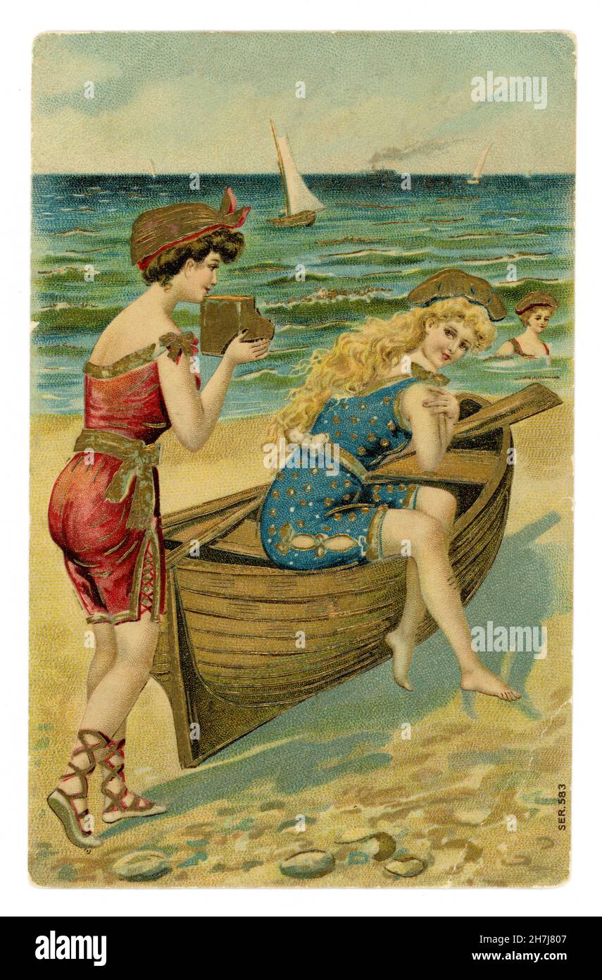 Affascinante originale edoardiano illustrato colore carta goffrata impreziosita da oro, di belle bellezze balneari, uno seduto su una barca a remi, uno con una macchina fotografica, Inghilterra U.K. circa 1905. Foto Stock