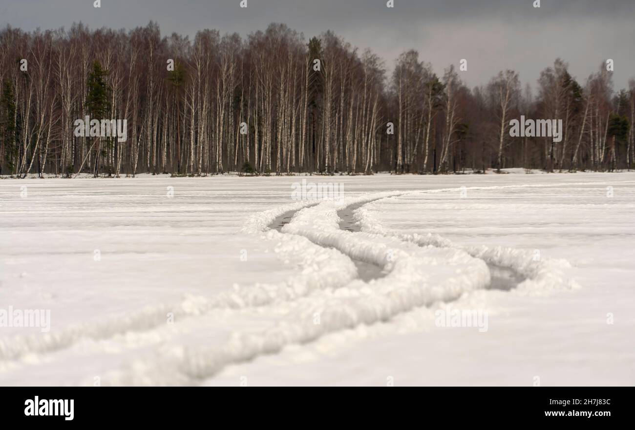 Ruote tortuose su un lago ghiacciato. Giorno d'inverno. Regione di Leningrad. Foto Stock