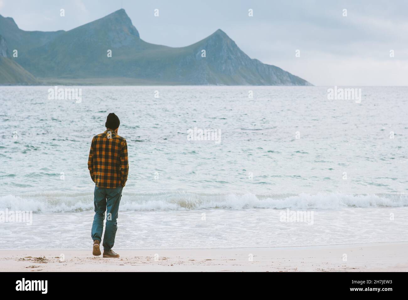 Uomo globetrotter a piedi sulla spiaggia Haukland in Norvegia isole Lofoten avventura viaggio stile di vita vacanze attive week-end ecoturismo all'aperto Foto Stock