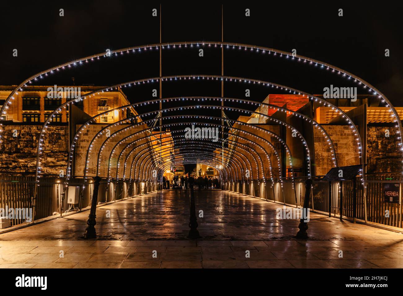Valletta,Malta.Evening strada pedonale illuminata da luci colorate, persone in movimento.vita notturna della città.illuminazione di strada festosa.città urbana Foto Stock