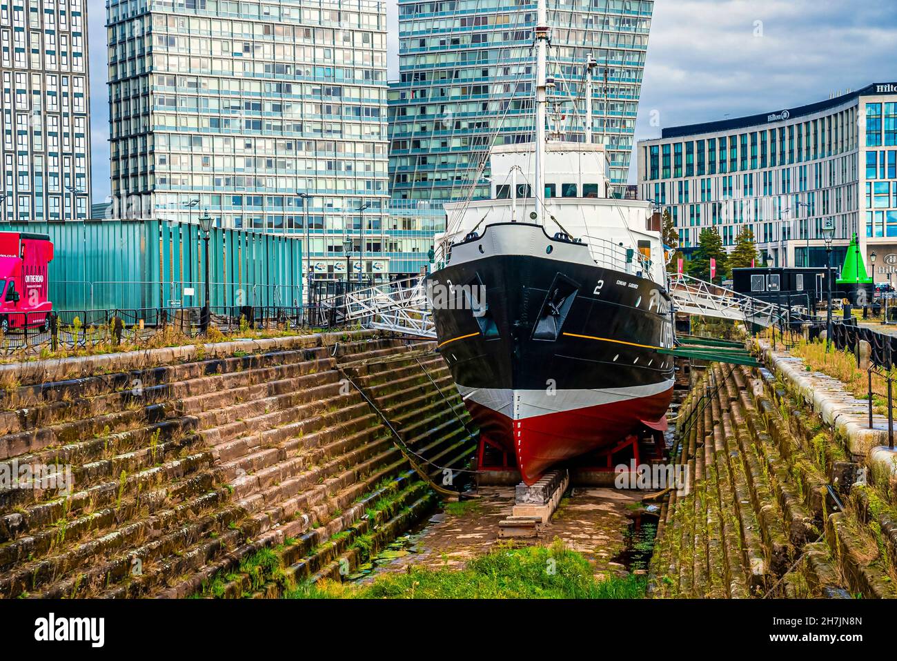 Nave a vela ormeggiata a Liverpool con edifici sullo sfondo Foto Stock