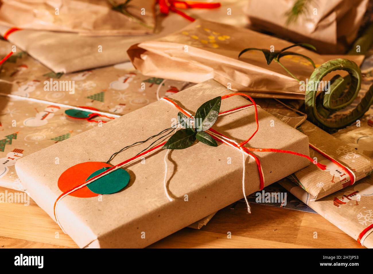 Regali di Natale Composition.Xmas con i nastri verdi rossi ed il decor.presenta del ramo dell'albero avvolto in carta riciclata artigianale e in vacanza di arco.Inverno della corda Foto Stock