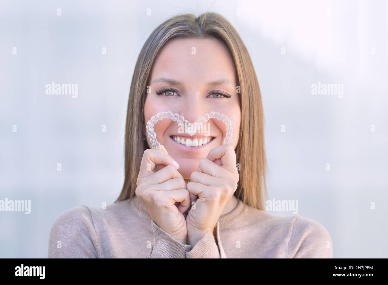 Donna con un sorriso perfetto dopo il trattamento invisibile allineatori dentali Foto Stock