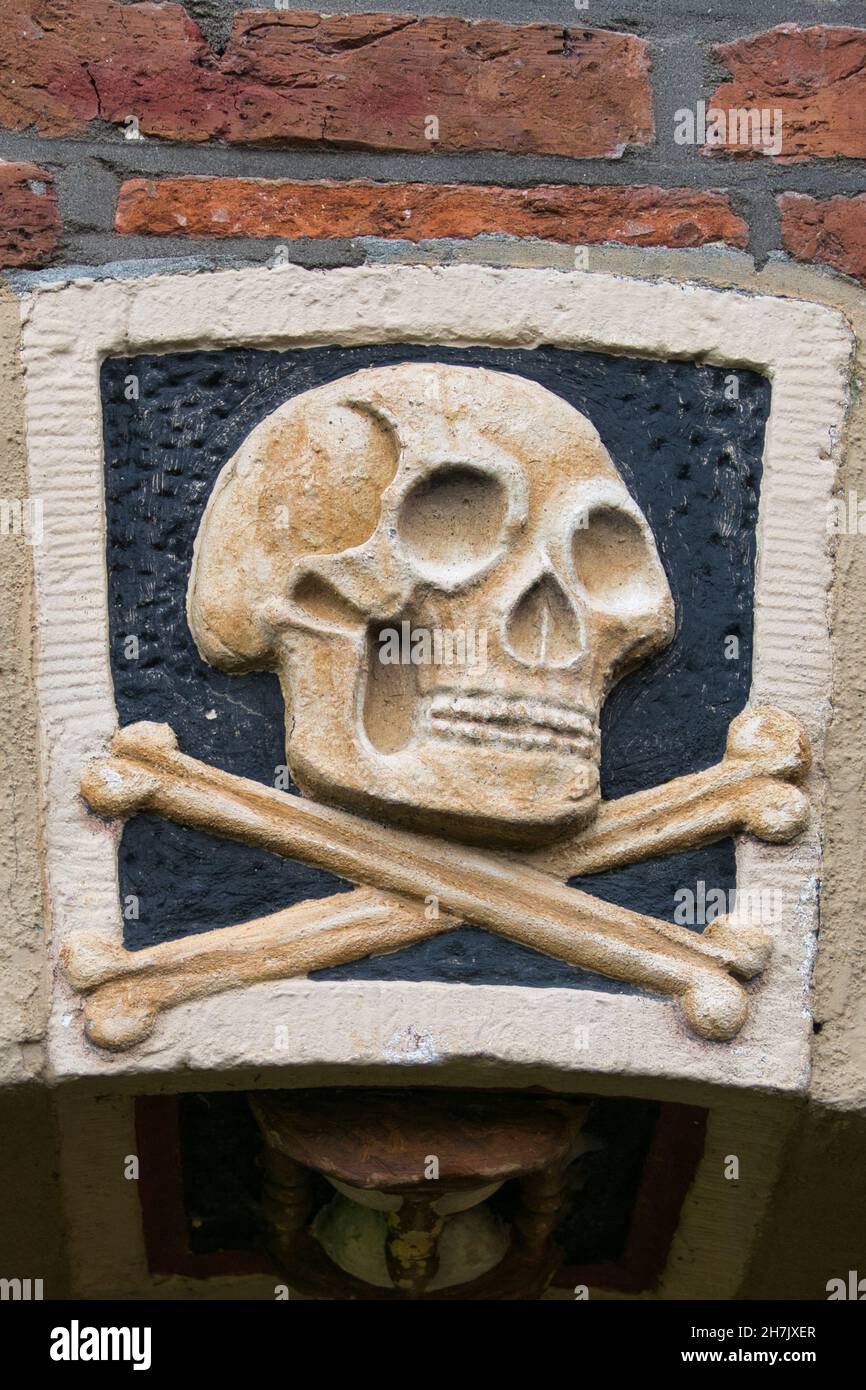 Cranio e ossa. Primo piano di una facciata in pietra del 18 ° secolo sulla chiesa torre (Torenkerk) a Winsum, Paesi Bassi Foto Stock