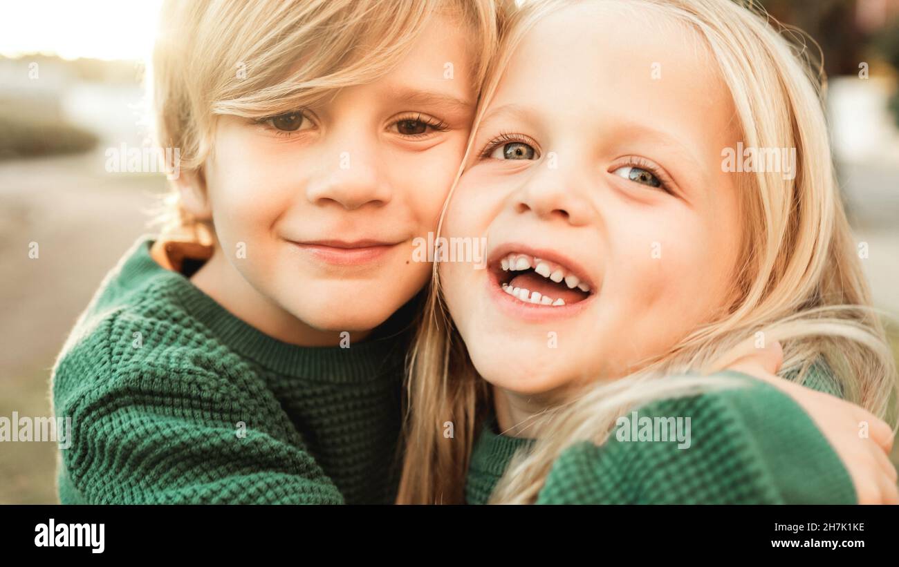 Ritratto di piccoli fratelli felici divertirsi all'aperto nel parco della città - famiglia, infanzia e amore concetto Foto Stock