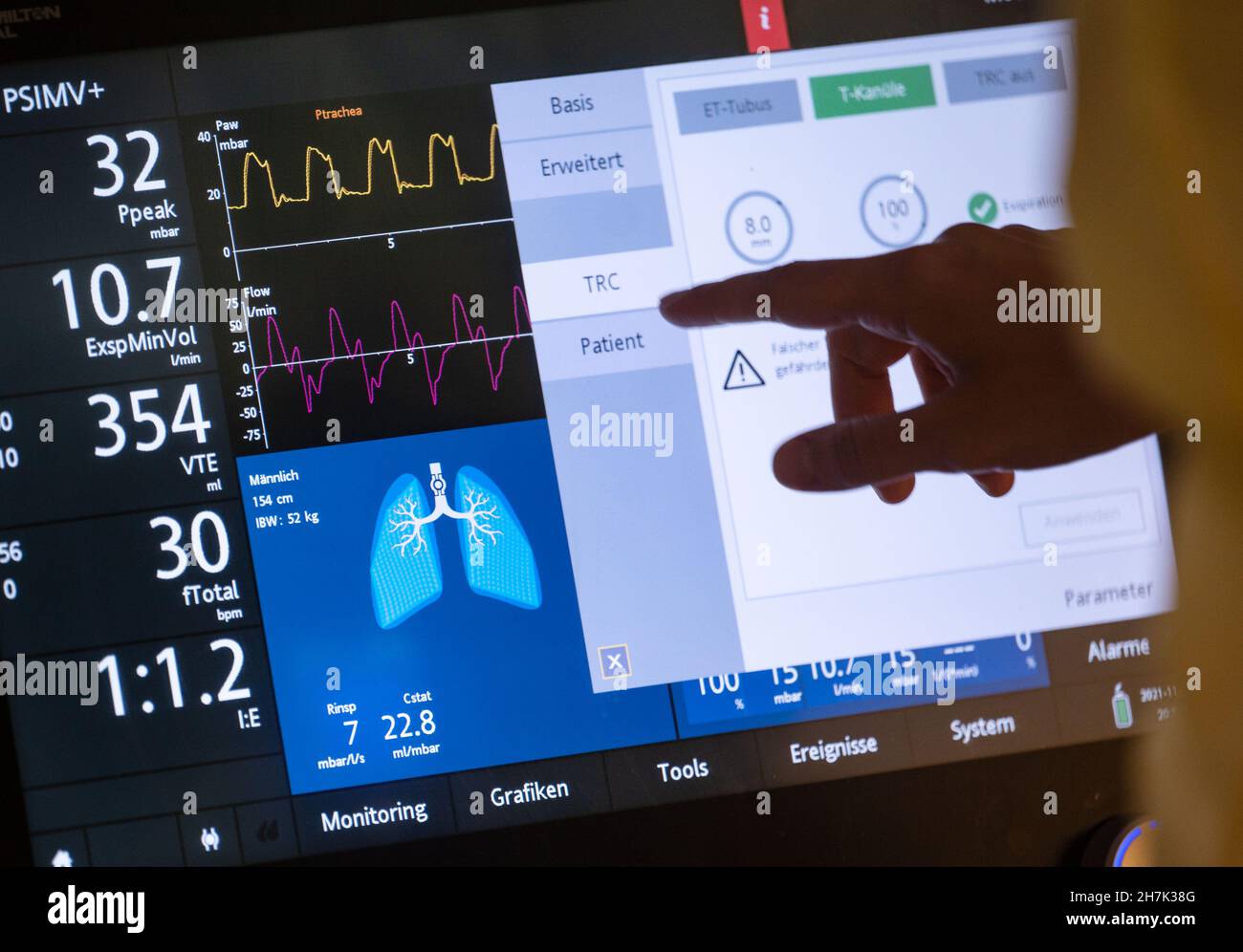 Stoccarda, Germania. 17 novembre 2021. Il personale infermieristico si trova in una sala paziente di un'area separata per i pazienti di Covid-19 di un'unità di terapia intensiva del Klinikum Stuttgart, di fronte al ventilatore di un paziente di Covid-19 che si trova in coma artificiale e viene ventilato. Credit: Marijan Murat/dpa/Alamy Live News Foto Stock