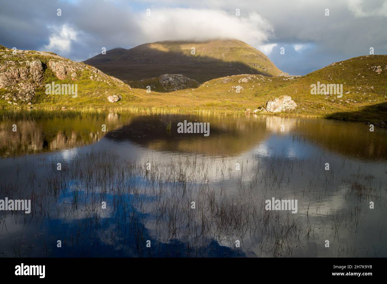 Regno Unito, Scozia, Wester Ross, Ross e Cromarty. Un lochan sulla strada per abbassare il Diabeg da Torridon, Bealach na Gaoithe. Verso il monte Beinn Alligin. Foto Stock