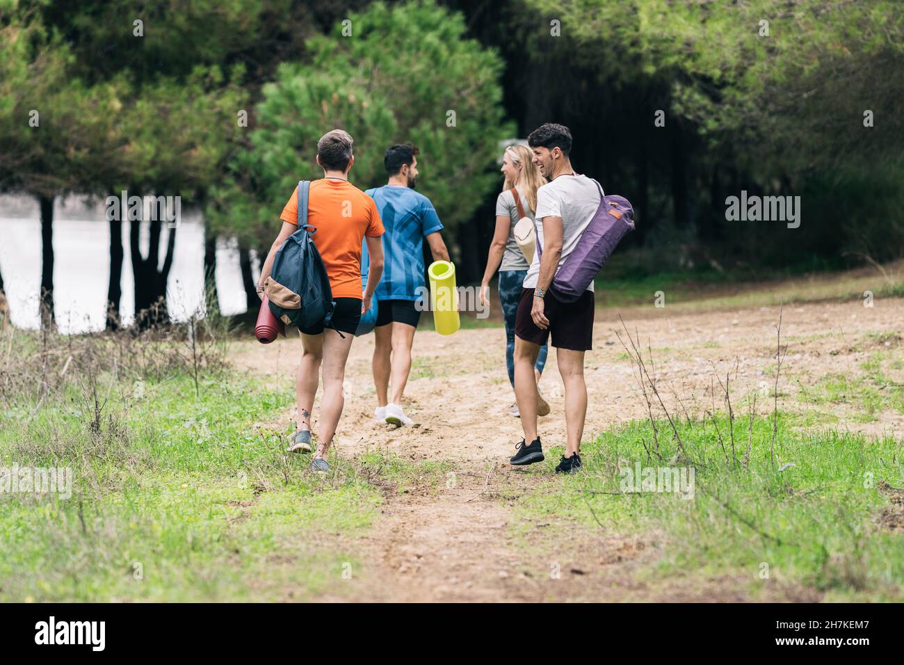Foto con spazio copia di persone che passeggiando nella foresta con tappeti yoga Foto Stock