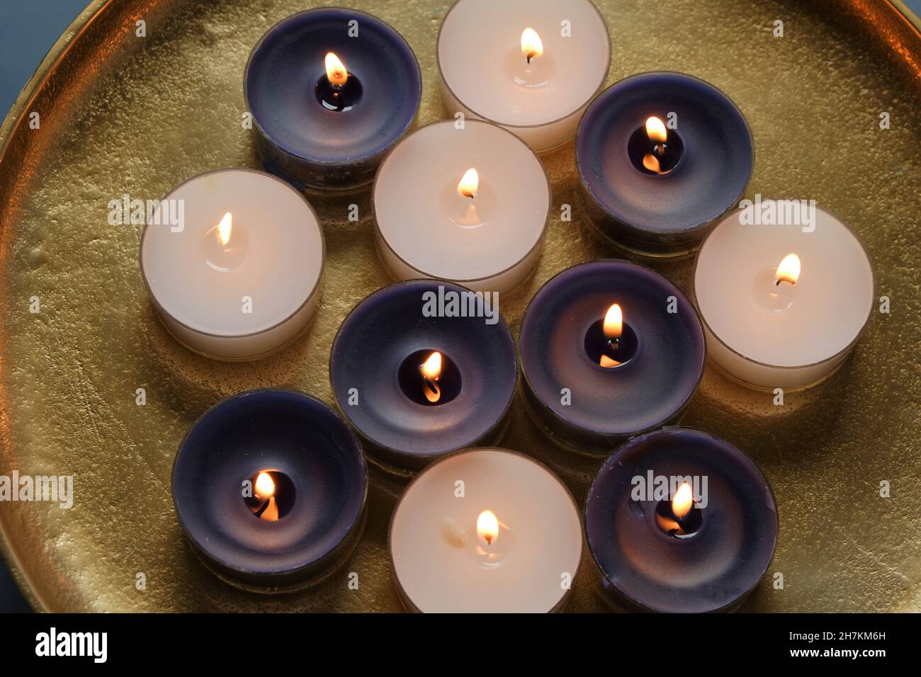 Candela fiamma. Candele che bruciano in un vassoio d'oro .Candles sfondo. Foto Stock