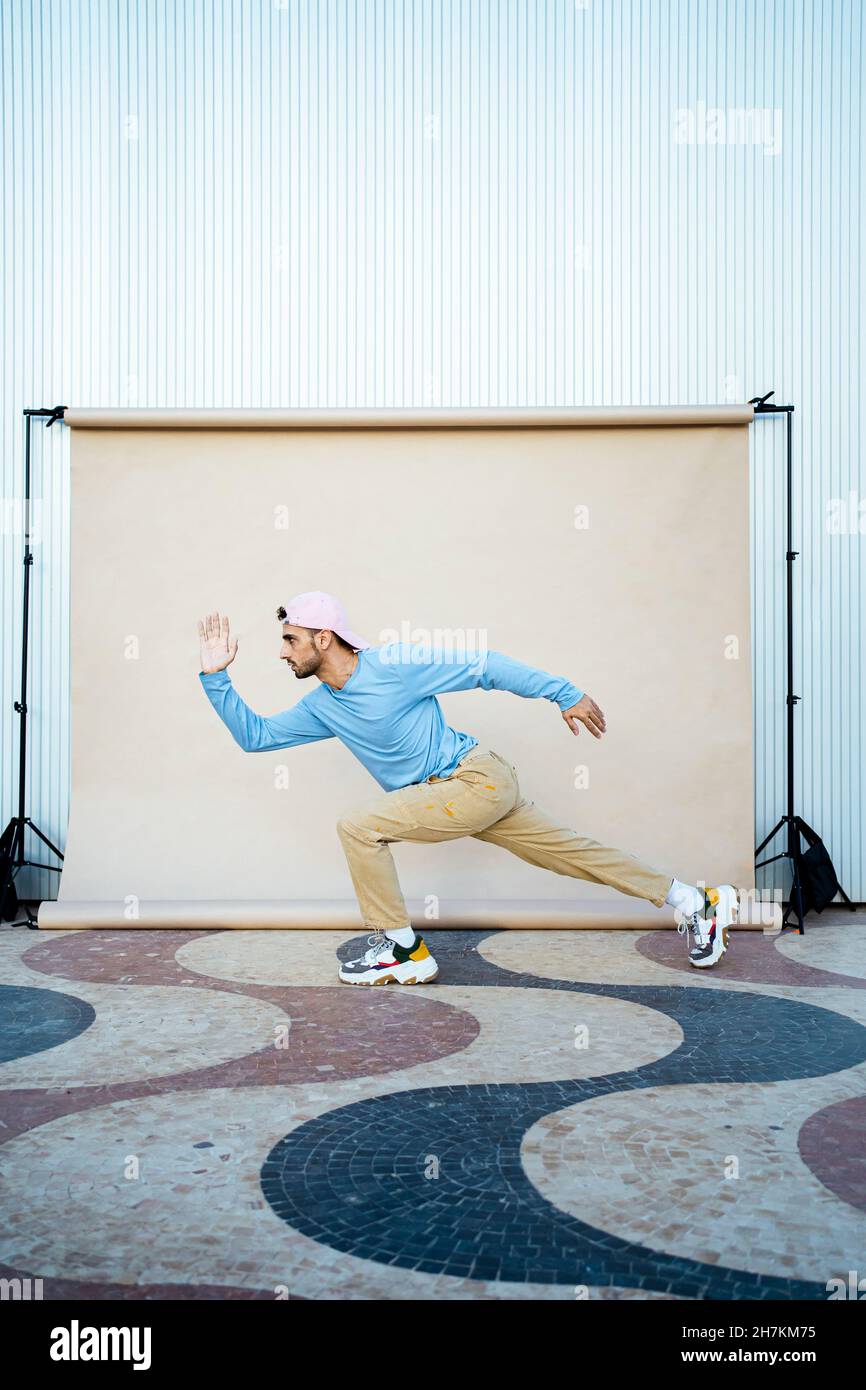 Uomo medio adulto che corre vicino al sfondo beige Foto Stock