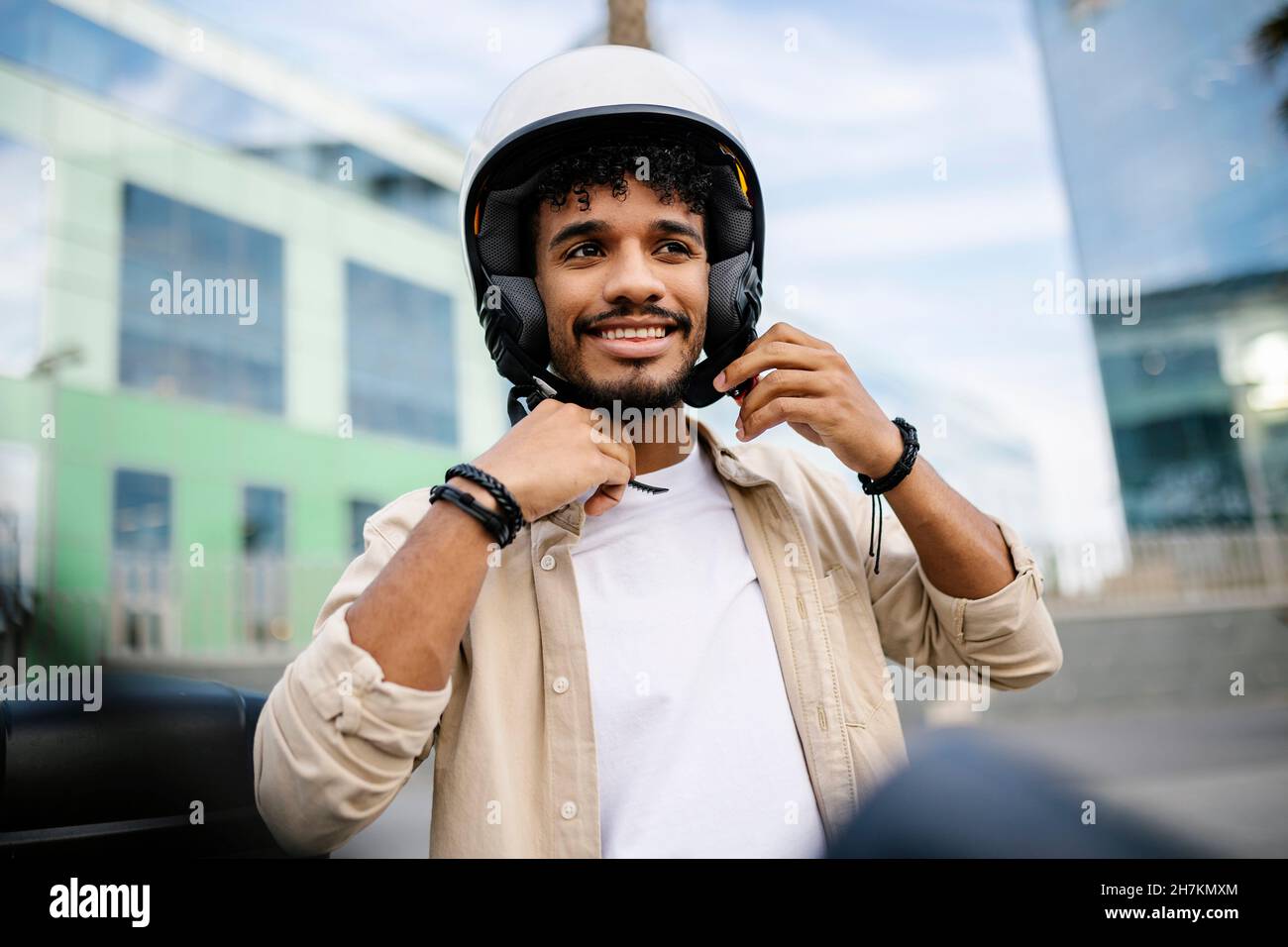 Uomo sorridente che indossa un casco Foto Stock