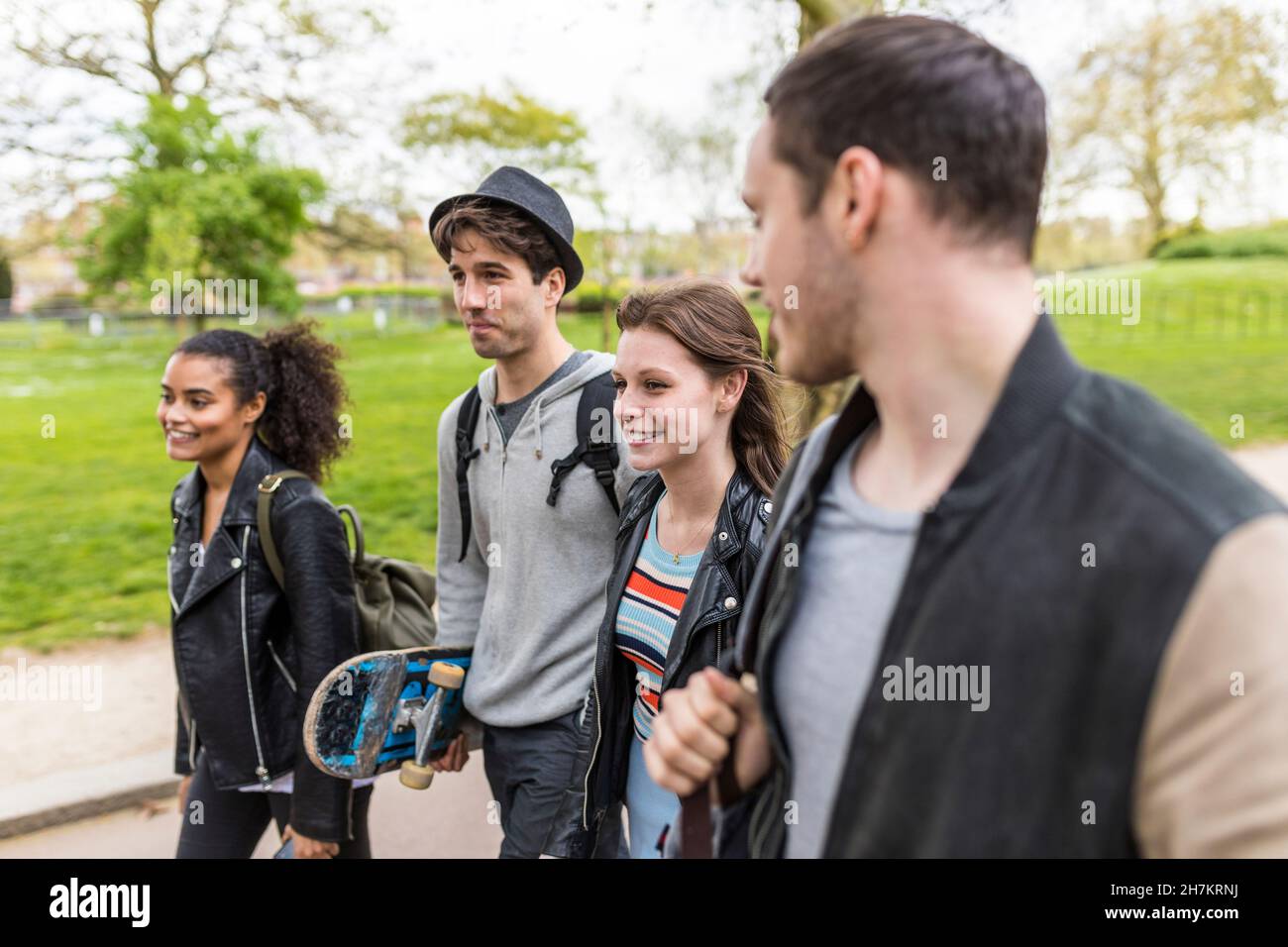 Gruppo multirazziale di giovani amici che camminano insieme nel parco Foto Stock