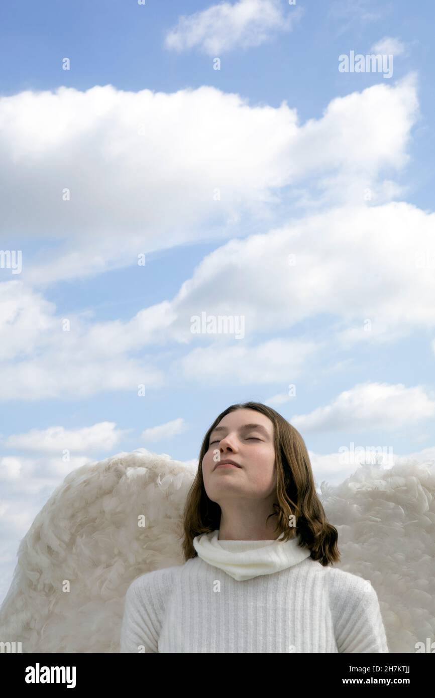Ragazza adolescente con le ali d'angelo e gli occhi chiusi Foto Stock