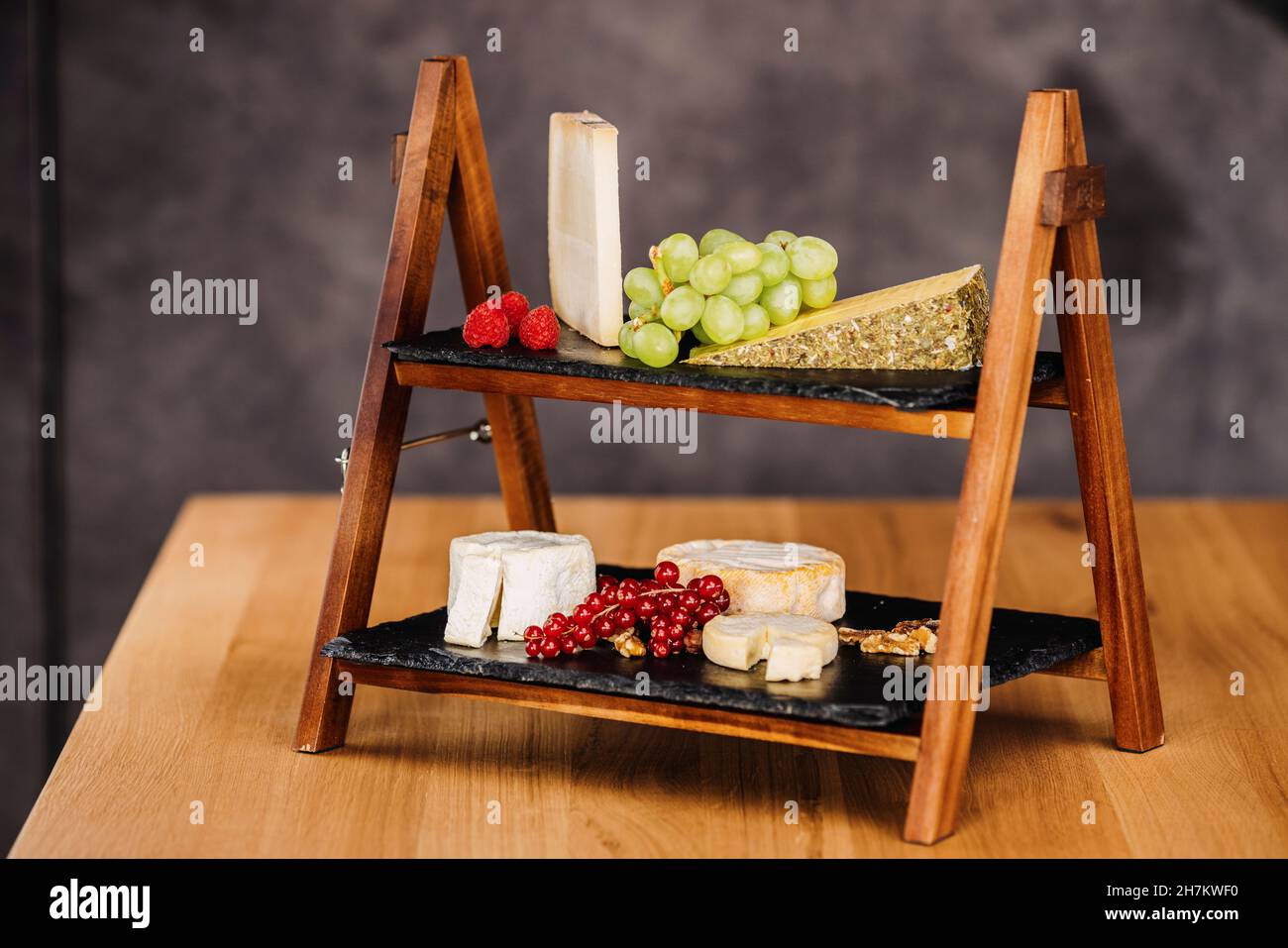 Studio di formaggi a tavola con vari tipi di formaggio e frutta cruda Foto Stock