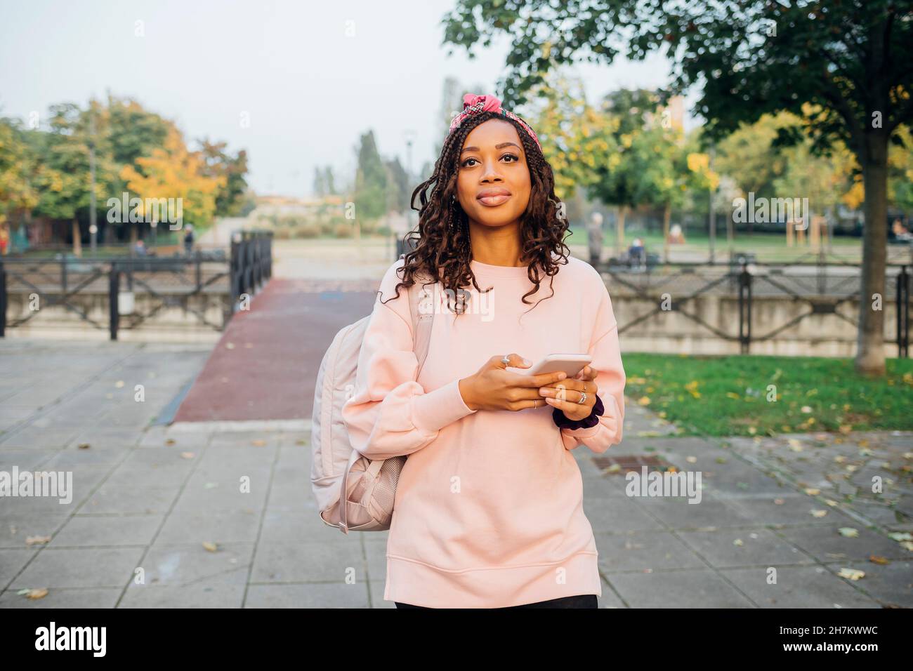 Giovane donna nera che si gode la città vivere all'aperto con smartphone - Milano, Lombardia, Italia - navigazione, ... Foto Stock