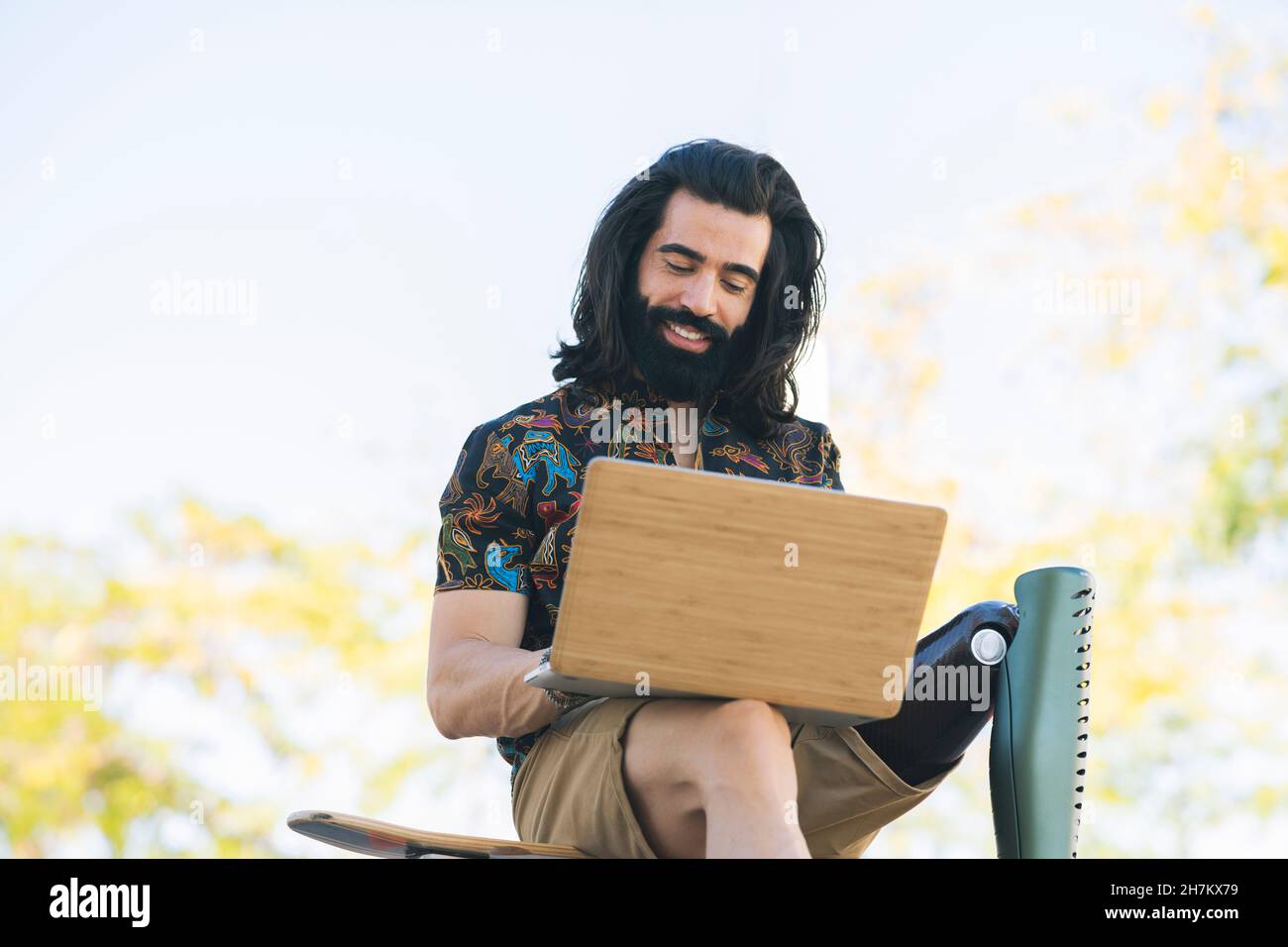 Hipster uomo con disabilità utilizzando il laptop sui gradini Foto Stock