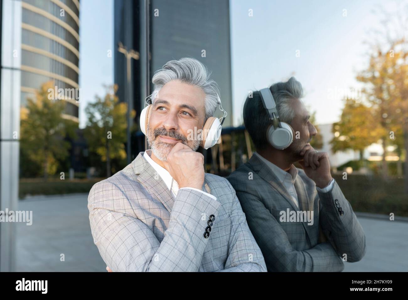 Un uomo d'affari felice che fa una stretta di mano davanti al muro giallo Foto Stock