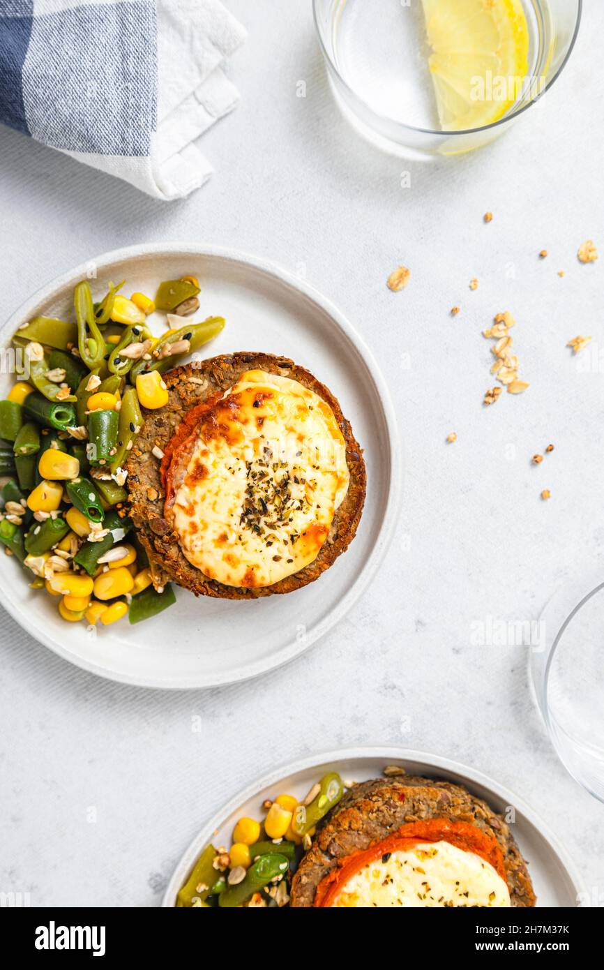 Hamburger di riso con mais e insalata di fagioli verdi nel piatto Foto Stock