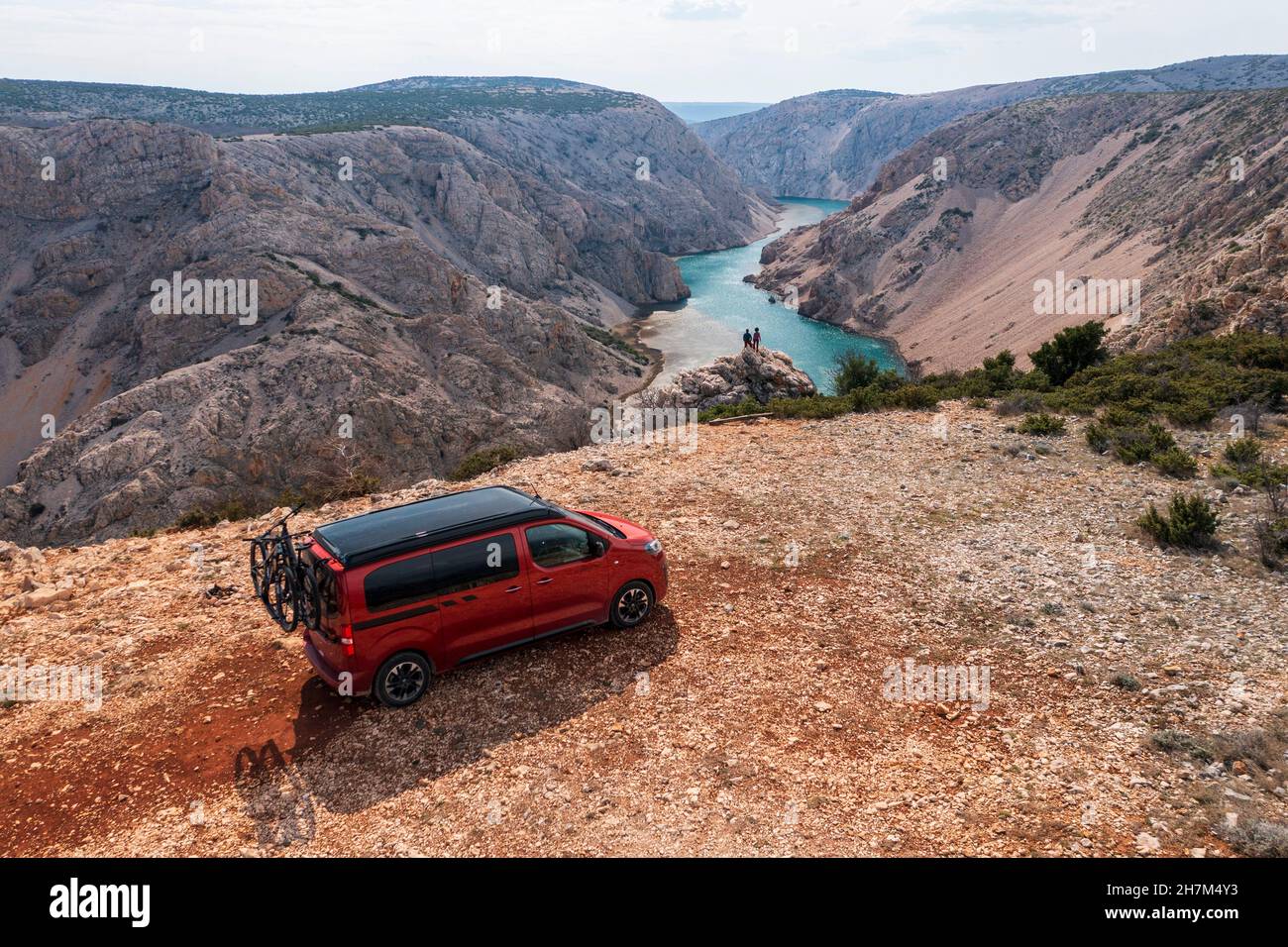 Viaggio su strada Croazia, camper su un campo con vista, due persone che guardano verso il basso nella valle Foto Stock