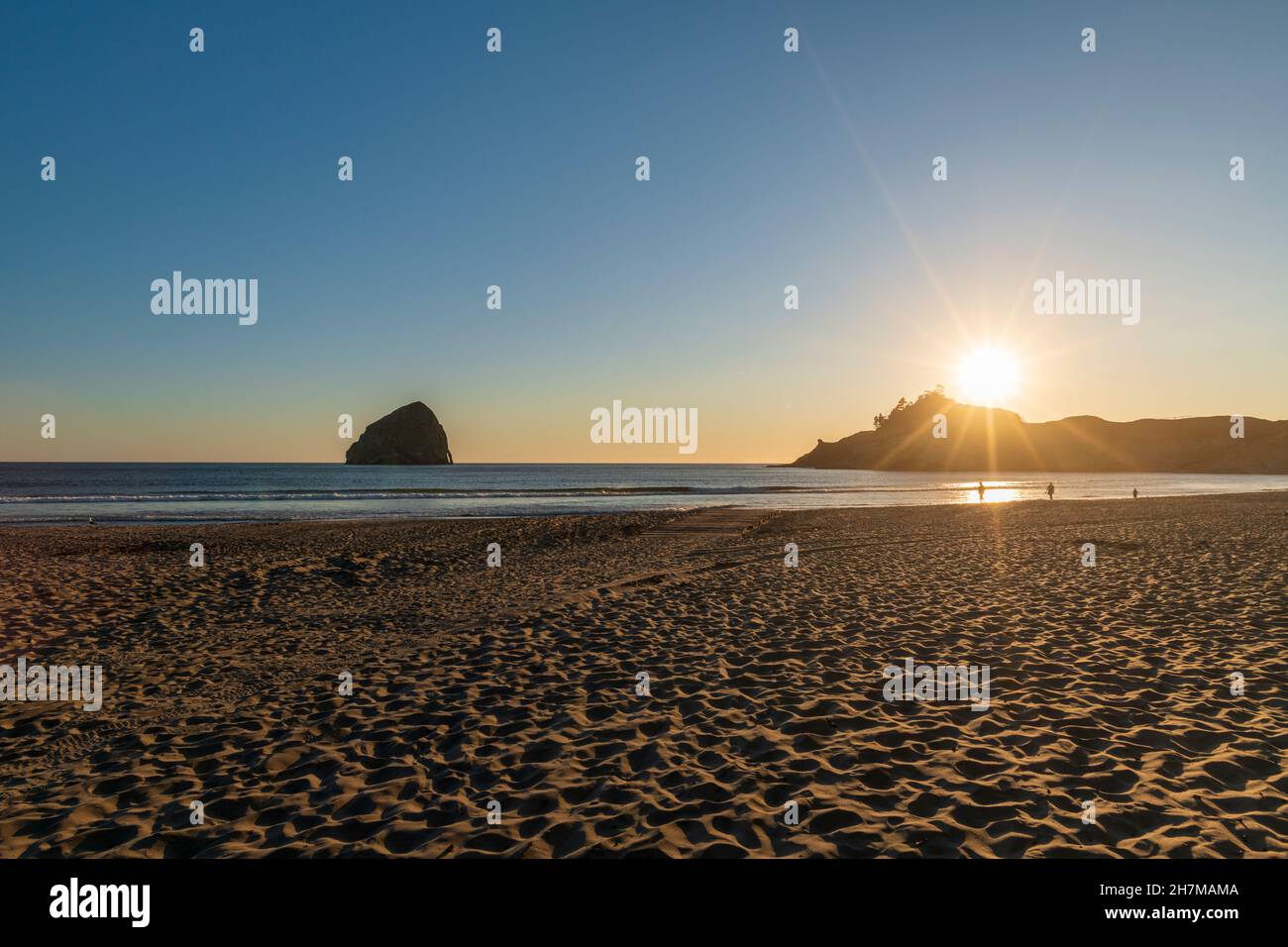 Persone che camminano alla luce del tramonto a Pacific City Beach, Oregon, USA Foto Stock