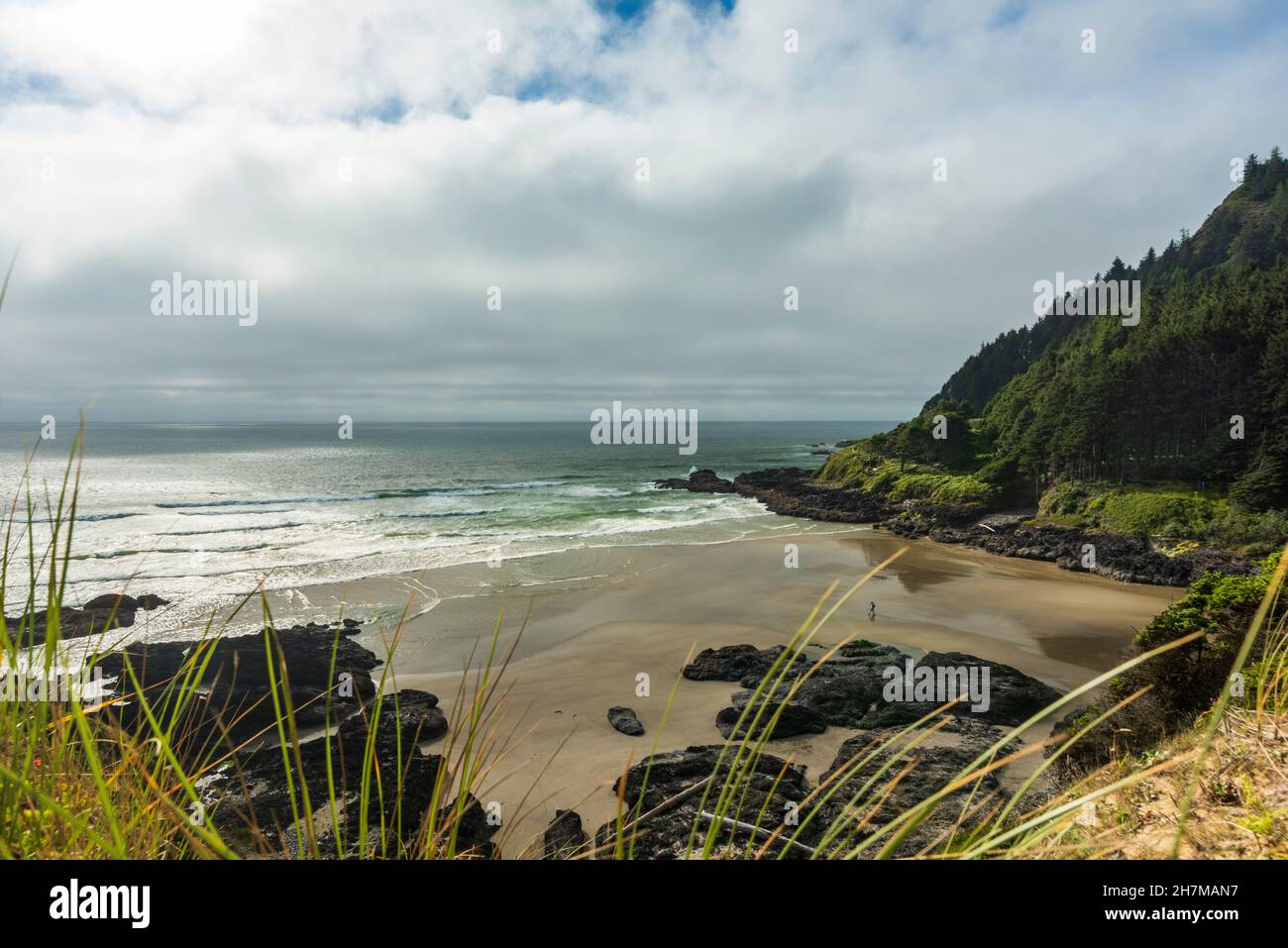 I visitatori della costa del Pacifico camminano durante una giornata nuvolosa a Cape Cove Beach vicino alla Cape Perpetua Scenic Area, Oregon, USA Foto Stock
