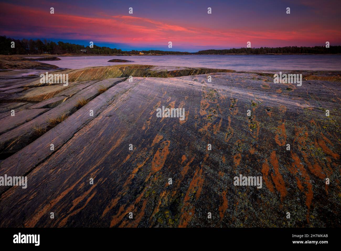 Belle formazioni rocciose e cieli colorati al crepuscolo al forno, lungo la costa dell'Oslofjord, Østfold, Norvegia, Scandinavia. Foto Stock
