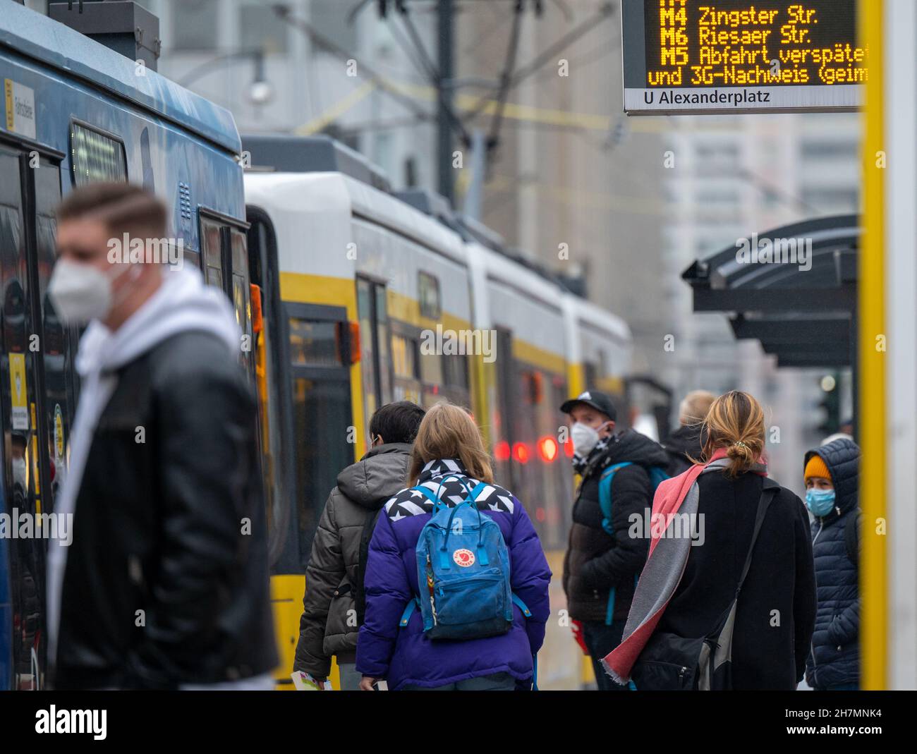 Berlino, Germania. 24 novembre 2021. I passeggeri che indossano maschere si imbarcaranno su un tram alla stazione di Alexanderplatz. Chi vuole guidare l'autobus e il treno, deve essere vaccinato, recuperato o testato per esso da mercoledì. Credit: Monika Skolimowska/dpa-Zentralbild/dpa/Alamy Live News Foto Stock