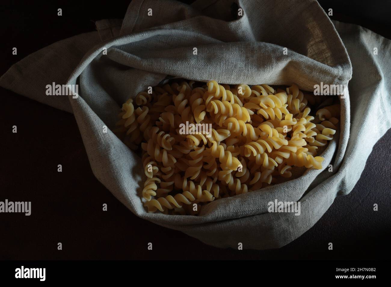 Pasta fresca fusilli su sfondo scuro. Direttamente sopra. Foto Stock