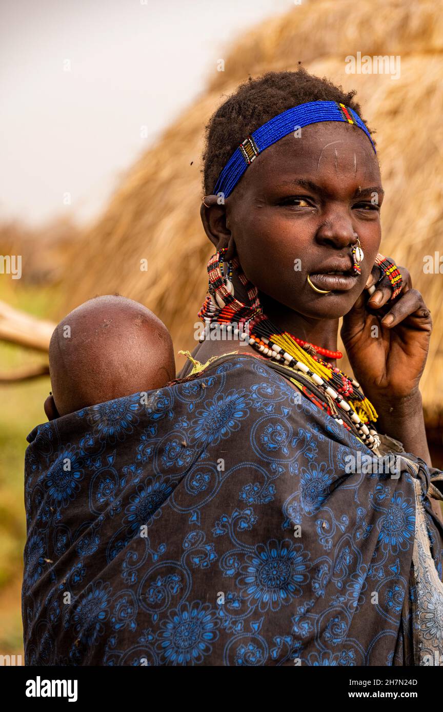 Donna con il suo figlio prima della sua capanna, tribù Jiye, Eastern Equatoria state, South Sudan Foto Stock