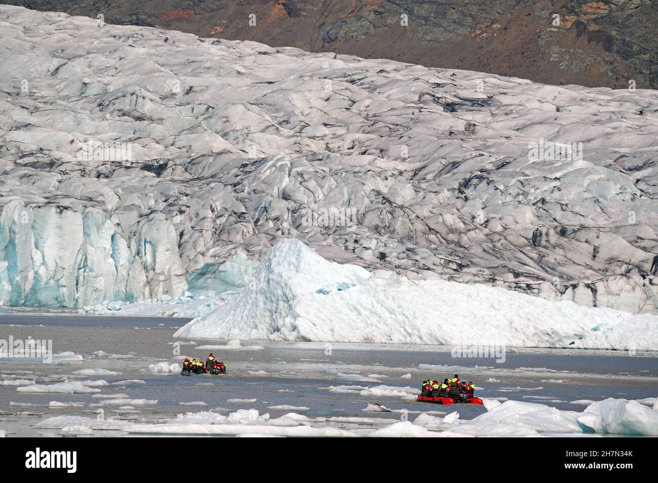 Ghiacciai e ghiacciai e piccole barche, ghiacciai e montagne sullo sfondo, Fjallsarlon, Parco Nazionale Vatnajoekull, Islanda Foto Stock