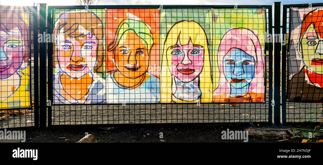 Ritratti colorati attaccati alla recinzione di una scuola di Berlino, Berlino, Germania Foto Stock