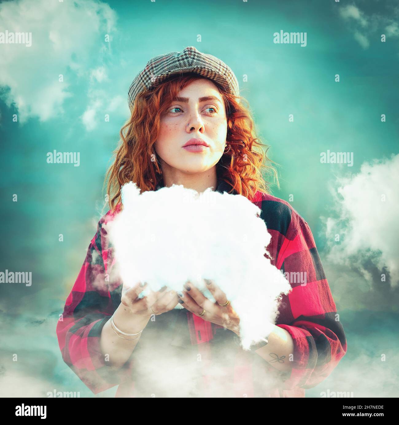 Foto di una ragazza dai capelli rossi con una nuvola in mano Foto Stock
