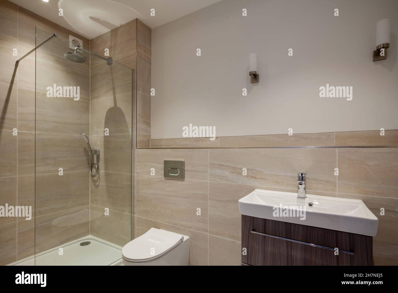 Camera doccia generica in casa con pareti parzialmente piastrellate, wc, box doccia con vetri e lavabo Foto Stock