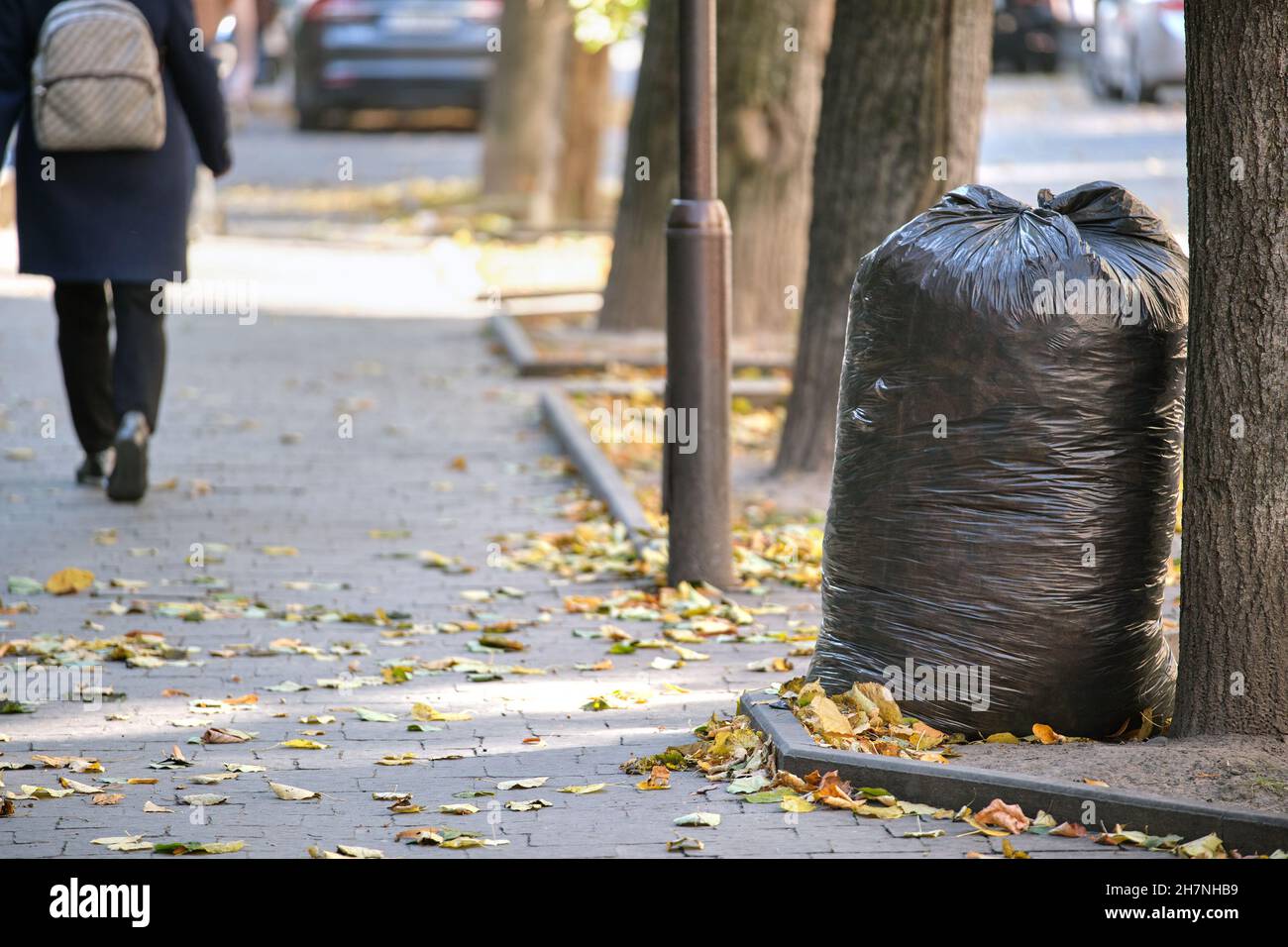 Mucchio di sacchi di rifiuti neri pieno di lettiera sinistra per pick up  sul lato della strada. Concetto di smaltimento rifiuti Foto stock - Alamy