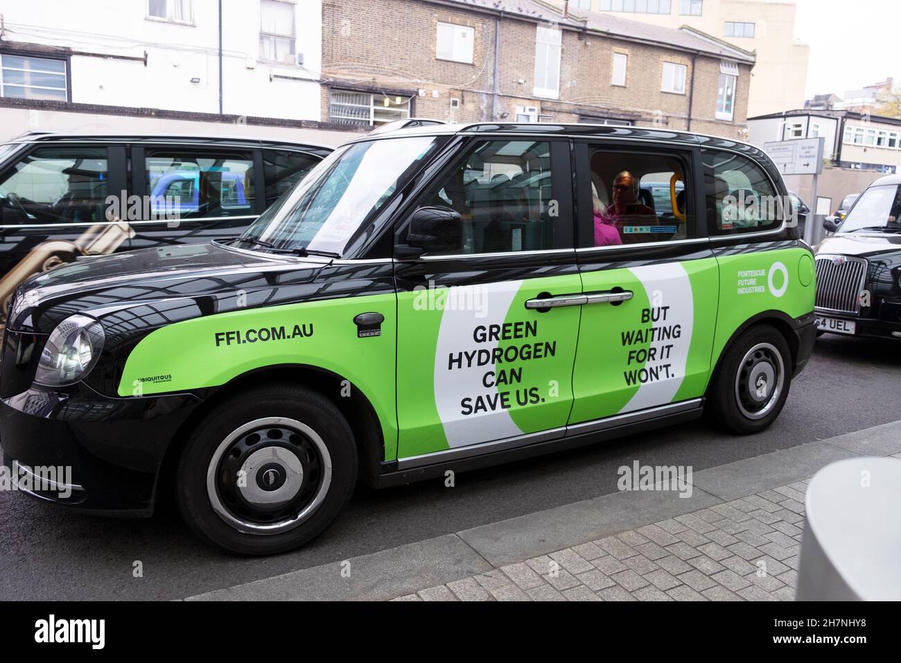 L'IDROGENO VERDE PUÒ SALVARCI. La pubblicità FFI FUEL sul lato di un taxi nero preleva i passeggeri alla stazione di Paddington a Londra, Inghilterra, Regno Unito, KATHY DEWITT Foto Stock