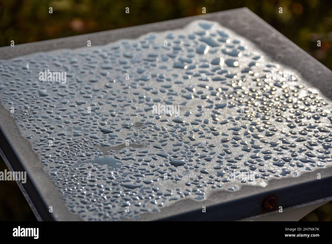 Gocce di pioggia o acqua goccia sul palo metallico, lucido e sparso. Foto Stock