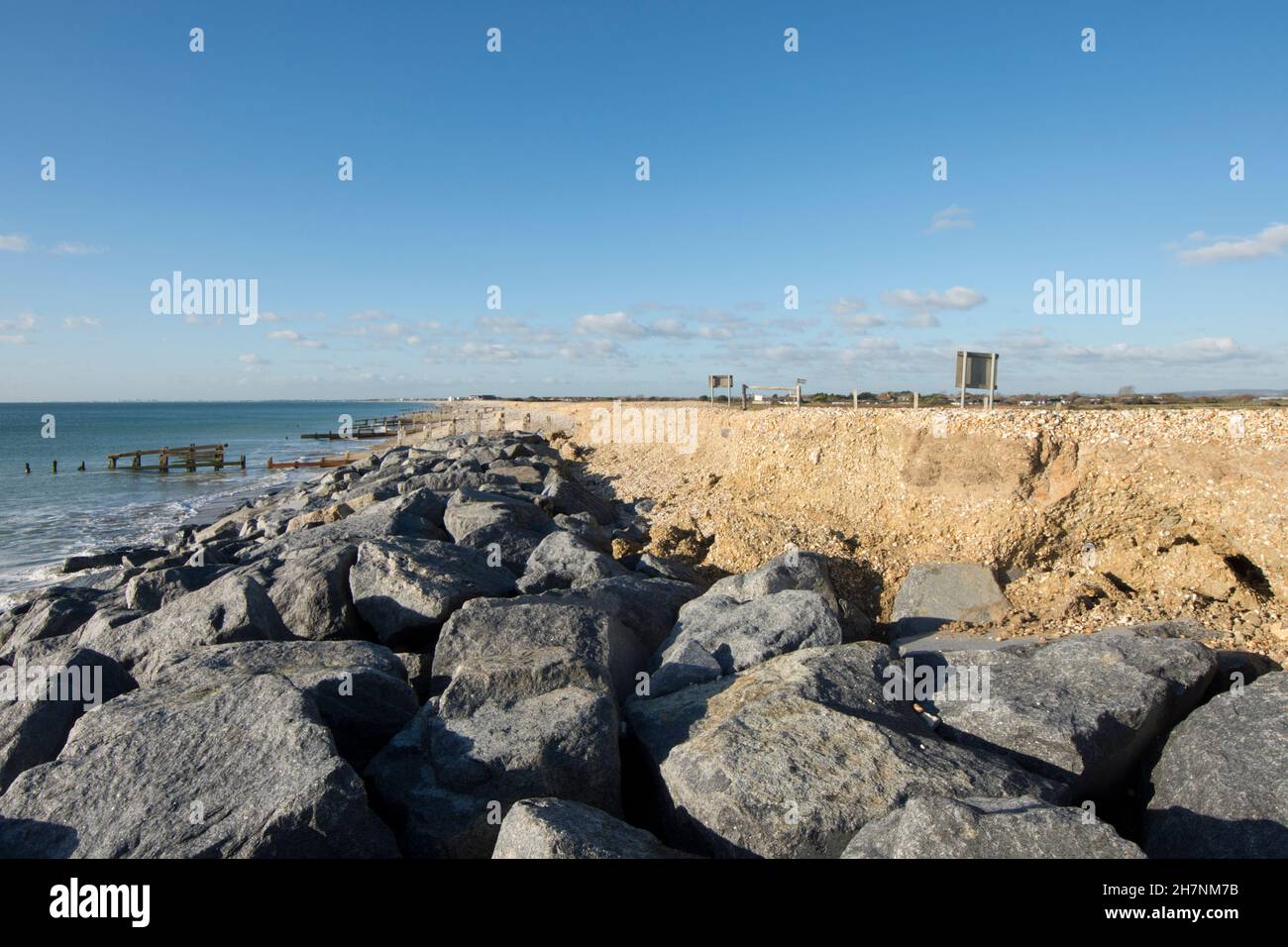 Erosione costiera, Sussex, difesa del mare, groynes di pietra, ciottoli e pietre, Separando il mare e Medmerry, vista nord-ovest verso Bracklesham, novembre Foto Stock