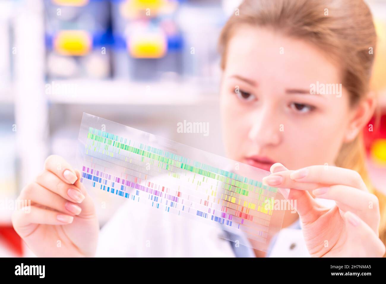 La giovane donna esamina un quadro di spettroscopia in una fisica quantistica laboratorio Foto Stock