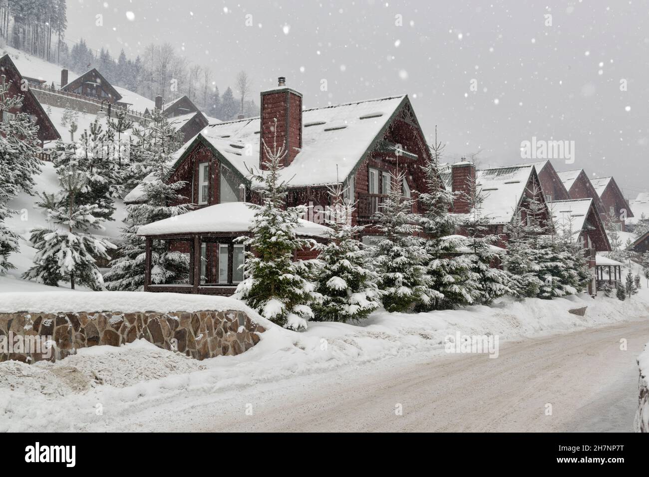 Bella scena vicino residenza vivente di una stazione invernale durante la nevicata Foto Stock