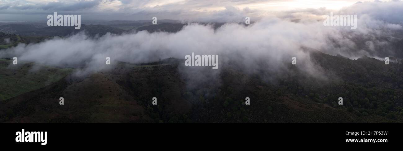 Le nuvole basse si distolano sulle colline che si trovano ad est della Baia di San Francisco, California. Questa regione panoramica diventa verde durante i mesi umidi e invernali. Foto Stock