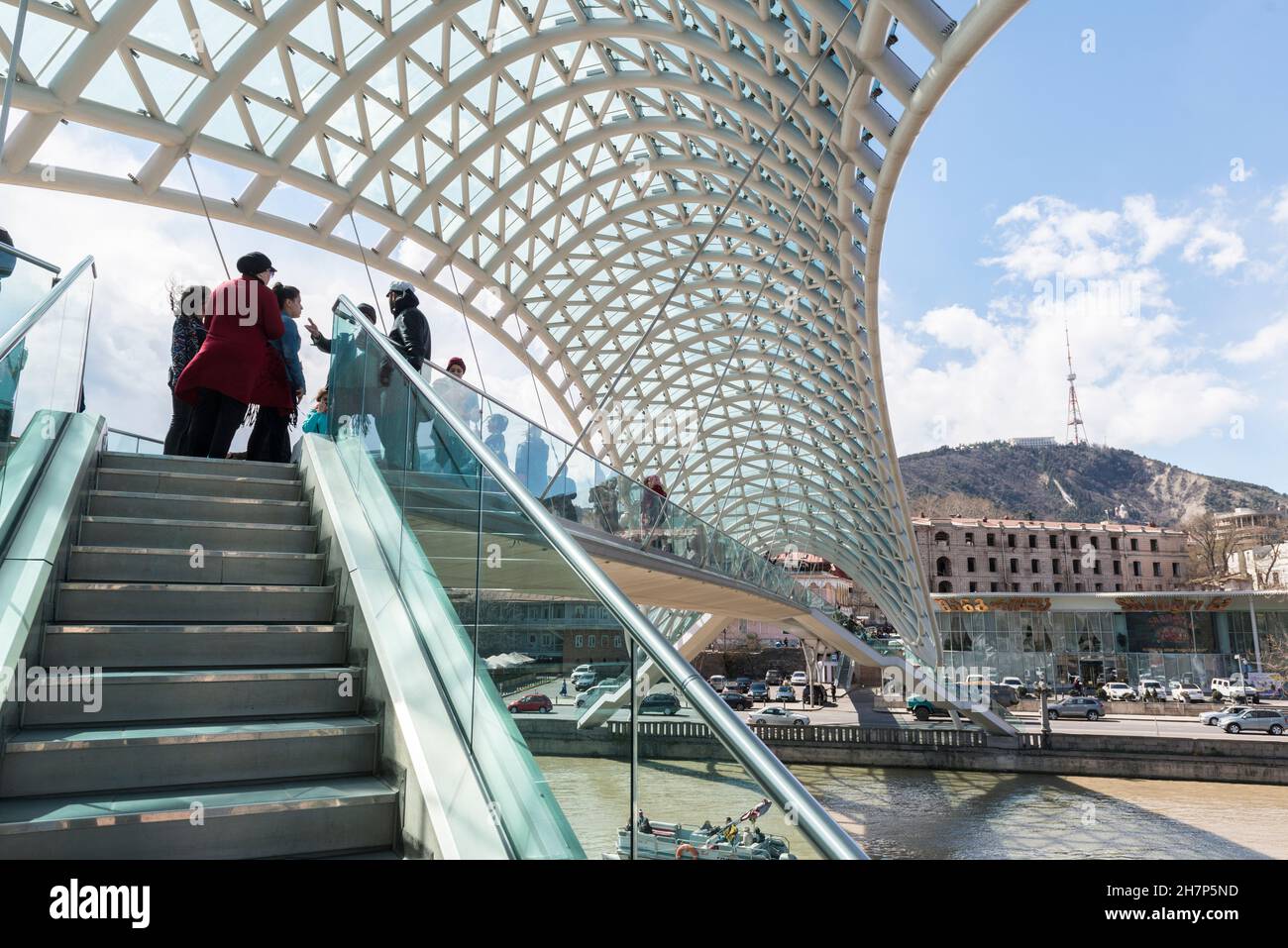 Pedoni sull'iconico Ponte della Pace sul fiume Kura a Tbilisi, Georgia, Caucaso Foto Stock