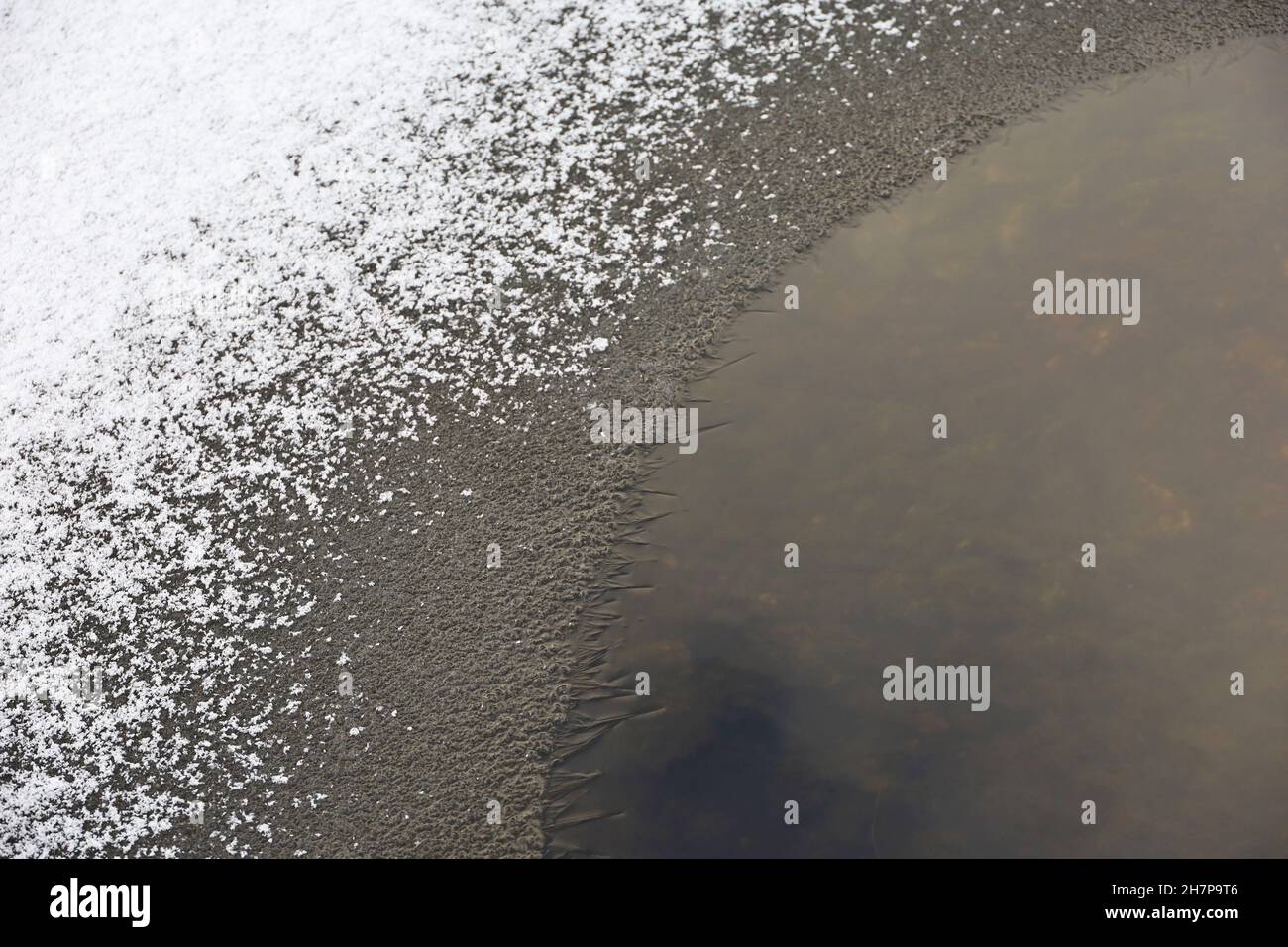 Ghiaccio sul fiume. Bordo di ghiaccio sulla riva coperto di neve, inizio stagione invernale Foto Stock