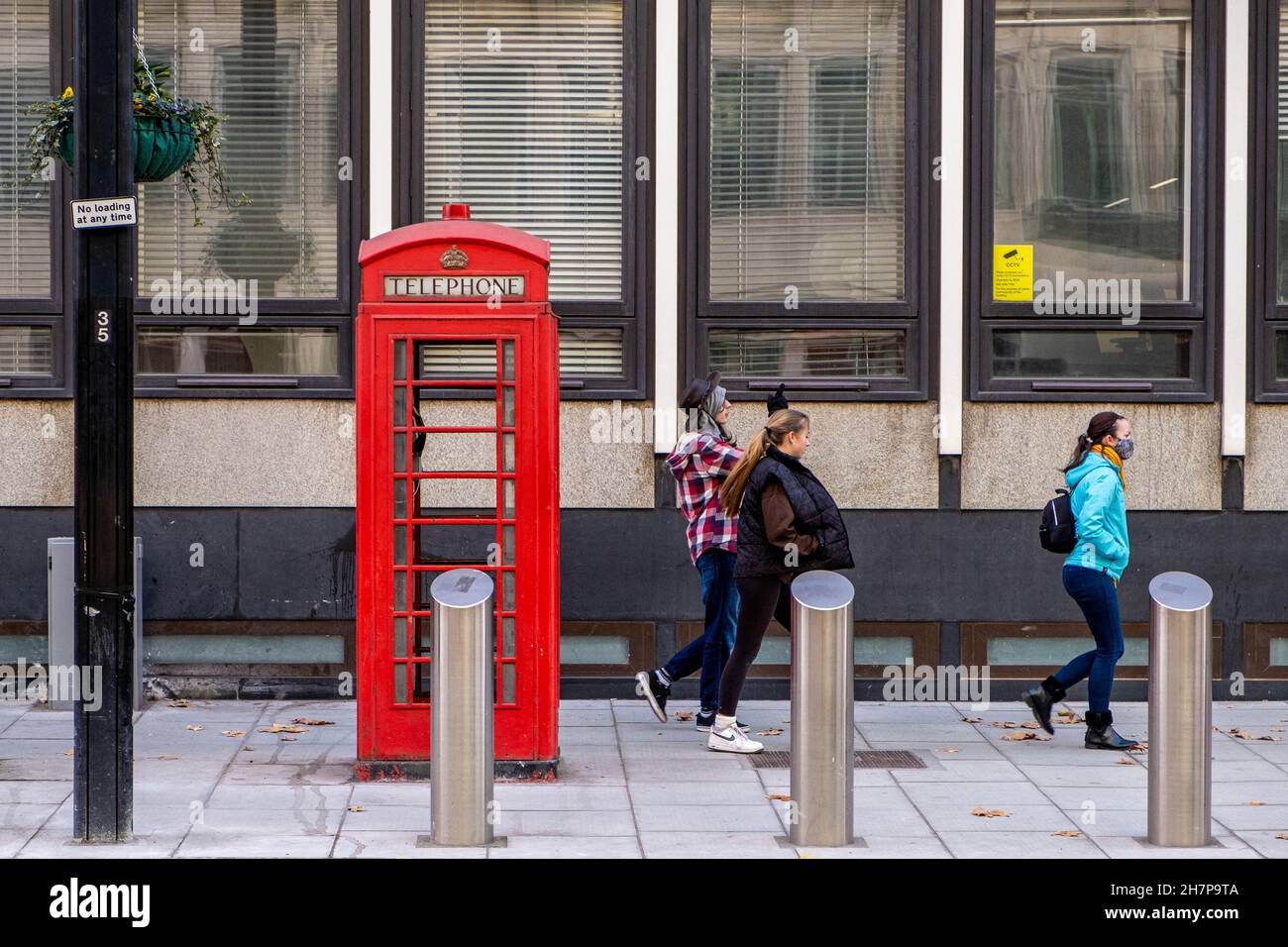Victoria London Inghilterra UK, novembre 21 2021, Family Walking passa accanto A un tradizionale Red Public Telepnoe Box in Victoria Street London Foto Stock